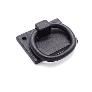 May include: Black metal ring pull handle with a square base. The handle is attached to a rectangular plate.
