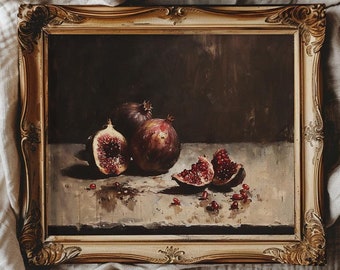 May include: A framed still life painting of pomegranates and figs. The painting is in a gold frame and features a dark background with a light brown surface. The pomegranates are cut open and show their red seeds. The figs are whole and have a dark purple color.