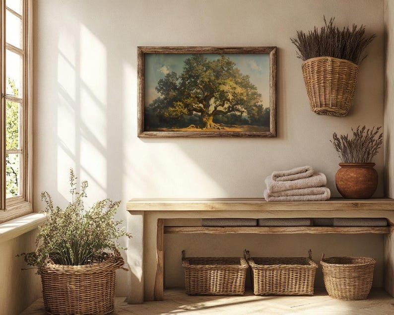 May include: A rustic wooden bench with four woven baskets underneath. The bench is against a white wall with a framed painting of a large tree and dried flowers in a woven basket hanging on the wall.