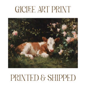 May include: Gicl&eacute;e art print featuring a brown and white calf resting in a grassy area surrounded by pink roses and lush greenery. The artwork has a vintage aesthetic. The text "GICLEE ART PRINT" is at the top, and "PRINTED & SHIPPED" is at the bottom.