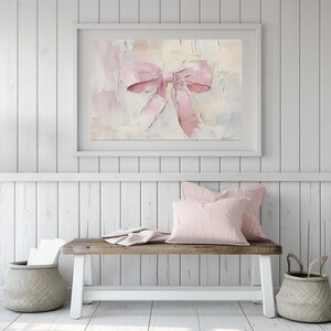 May include: A framed painting of a pink bow on a textured background. The bow is tied with a large, soft loop and the background is a mix of light pink, cream, and white.