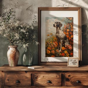 May include: A framed print of a black and white dog sitting in a field of orange and yellow flowers. The dog is looking to the left of the image.