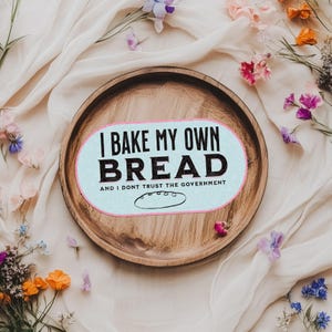 May include: A wooden serving tray with a light blue and white sticker that says "I bake my own bread and I don't trust the government".