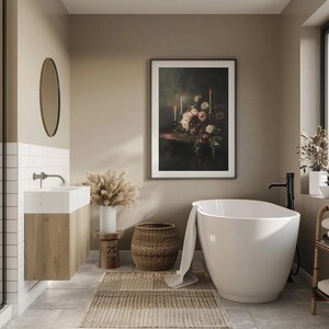 Puede incluir: Una ba&ntilde;era blanca independiente con una cesta de mimbre marr&oacute;n y una toalla blanca en un ba&ntilde;o con paredes beige y una impresi&oacute;n floral enmarcada.