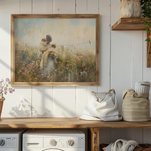 May include: A framed painting of a woman holding two children in a field of flowers. The painting is in a light wood frame and hangs on a white wall.