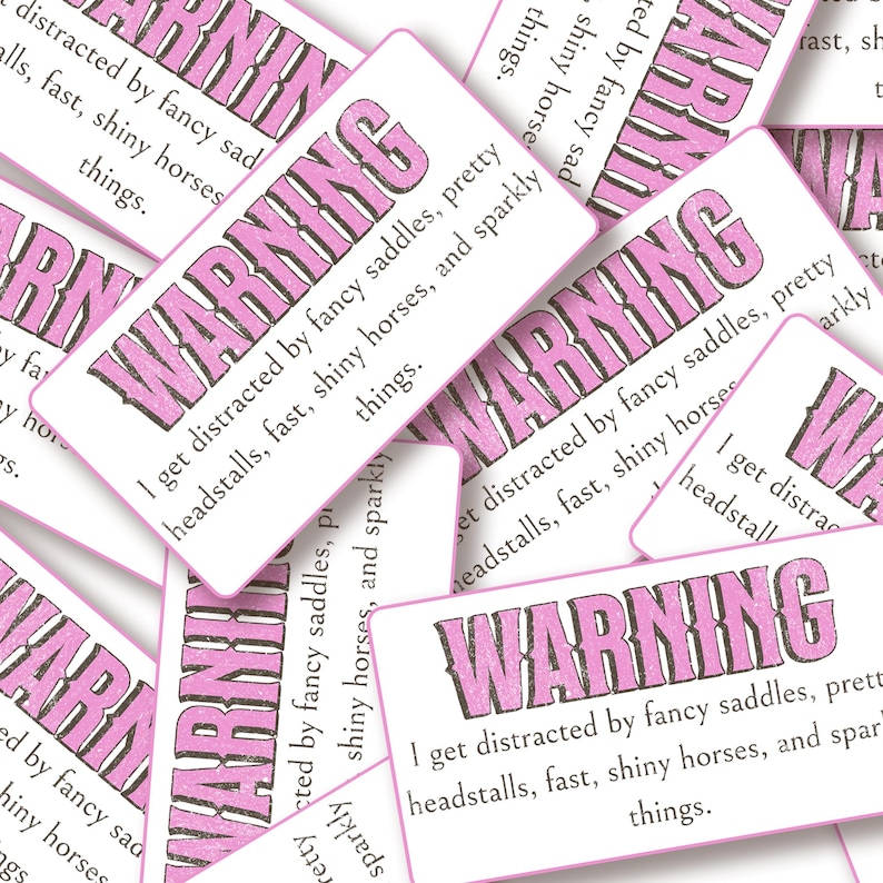 May include: A collection of rectangular white stickers featuring the word WARNING in bold pink letters. Below the text, each sticker reads: I get distracted by fancy saddles, pretty headstalls, fast, shiny horses, and sparkly things.