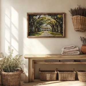 May include: A wooden bench with three woven baskets underneath. The bench is against a white wall with a framed painting of a house with trees above it. There are two dried flower arrangements in woven baskets on the wall.