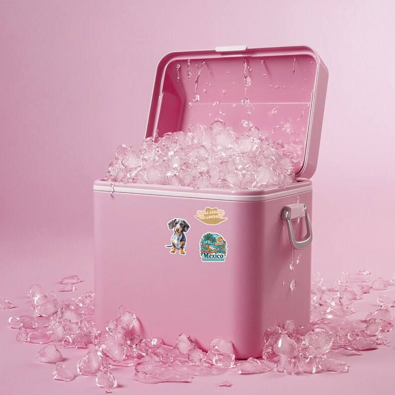 Puede incluir: Una nevera port&aacute;til de color rosa brillante con la tapa abierta, llena de cubitos de hielo transparentes. La parte frontal de la nevera tiene dos pegatinas: una que representa un perro salchicha y otra una escena de playa tropical con el texto Mexico.