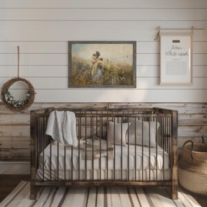May include: A rustic wooden crib with a white mattress and a white blanket. A framed painting of a woman holding a child in a field of flowers hangs on the wall above the crib. A framed print with the text "Let her sleep" hangs on the wall to the right of the crib.