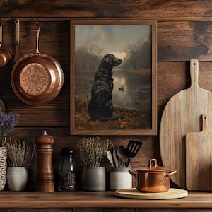 Puede incluir: Una pintura enmarcada de un labrador retriever negro sentado junto a un lago con patos en el fondo. La pintura est&aacute; colgada en una pared de madera r&uacute;stica con ollas de cobre y una tabla de cortar de madera.