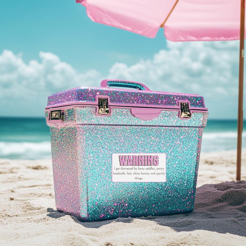 May include: A rectangular cooler with a glittery pink and teal gradient finish, featuring a top handle and metal latches. A white rectangular sticker on the front displays the text: WARNING I get distracted by fancy saddles, pretty headstalls, fast, shiny horses, and sparkly things.