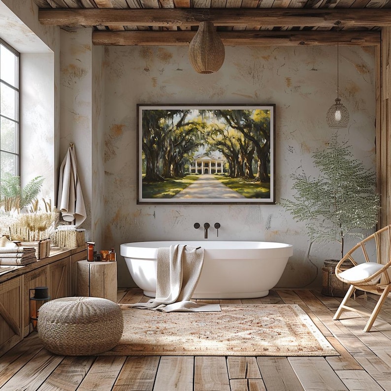 May include: A white freestanding bathtub with a beige towel draped over the edge, set in a rustic bathroom with exposed wooden beams, a large framed painting of a Southern plantation, and a woven rug on the floor.