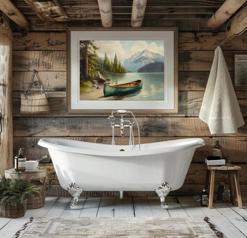 May include: A clawfoot bathtub with ornate silver feet is the focal point of a rustic bathroom. A framed landscape painting hangs above the tub. A small wooden stool and a potted plant add to the cozy atmosphere.