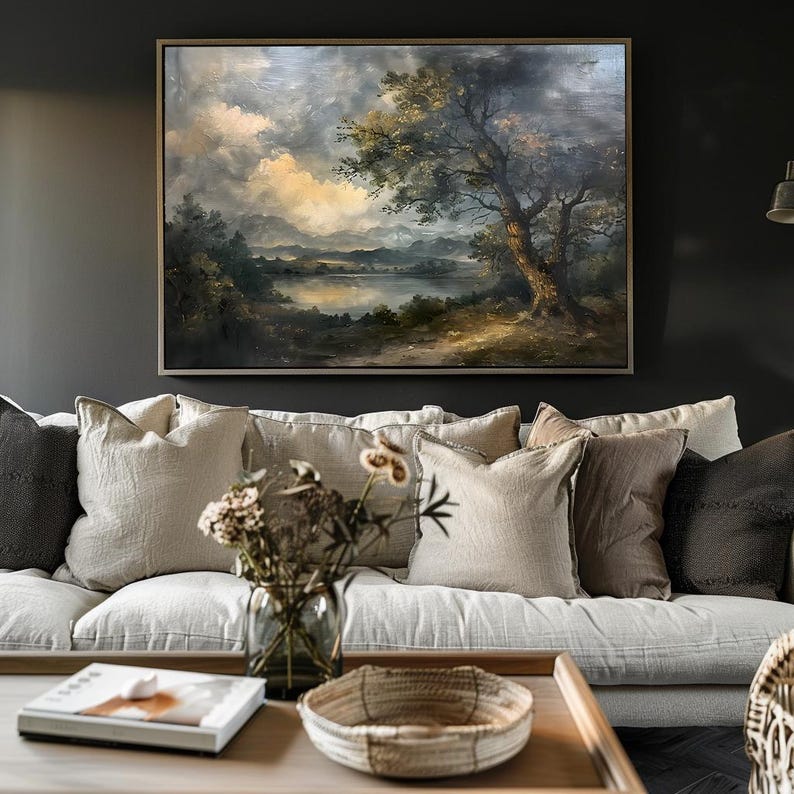 May include: A framed oil painting depicting a landscape scene with a lake, trees, and a cloudy sky. The painting is in a rustic style and features muted colours.