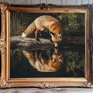 May include: A framed painting of a fox drinking from a body of water. The fox has reddish-orange fur and is reflected in the water. The painting is in a gold ornate frame, with a dark background of foliage.