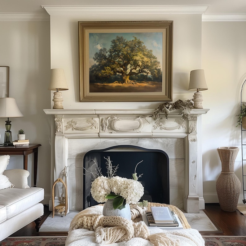 May include: A white marble fireplace with a black fireguard and a framed painting of a large oak tree above it. A white vase with white hydrangeas sits on a white ottoman in front of the fireplace.