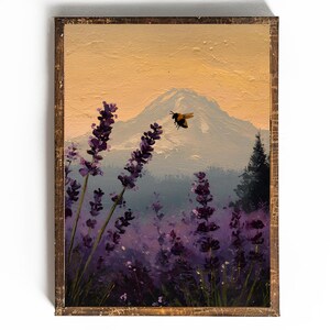 May include: Oil painting of a lavender field with a mountain backdrop and a bee in flight. The artwork features purple lavender, a mountain with a snow-capped peak, and a warm-toned sky. The painting is framed in a rustic wooden frame.