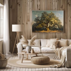 May include: A living room interior with a white sofa, a wooden coffee table, and a large framed painting of a tree on a wood wall. The painting is in a rustic style and features a large tree with green leaves and a brown trunk. The room is decorated with a beige rug, a wicker basket, and a floor lamp.