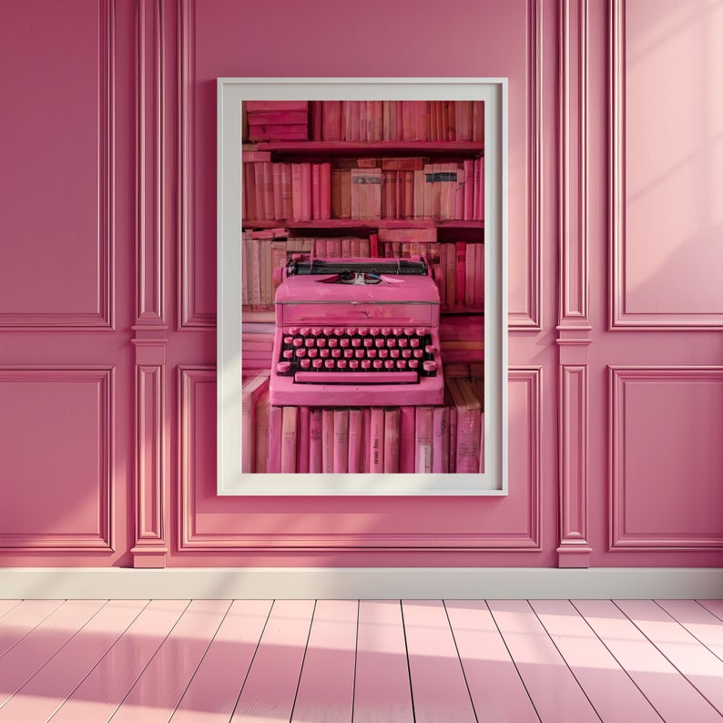K&ouml;nnte beinhalten: Ein gerahmter Druck einer rosafarbenen Schreibmaschine auf einem Regal mit rosafarbenen B&uuml;chern. Die Schreibmaschine ist scharf gestellt und die B&uuml;cher im Hintergrund sind verschwommen.