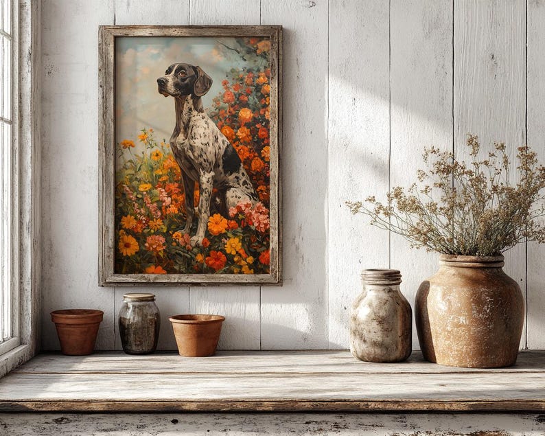 May include: A framed painting of a black and white dog sitting in a field of orange and yellow flowers. The painting is hanging on a white wood wall with a vase of dried flowers and three terracotta pots on a white wood shelf.