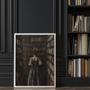 May include: A framed photograph of a woman in a long, dark dress standing in a library with bookshelves lining the walls.