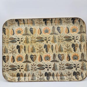 May include: Rectangular serving tray with a repeating pattern of stylized leaves in shades of brown, green, and peach on a cream-colored background. The tray has rounded corners and a slightly distressed appearance.