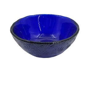 Può includere: Una piccola ciotola di vetro blu con un design testurizzato e smerigliato. La ciotola è perfetta per servire spuntini o salse.