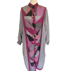 May include: A long, gray, tweed coat with a purple, pink, and black patchwork design. The coat has a high collar and a button closure.