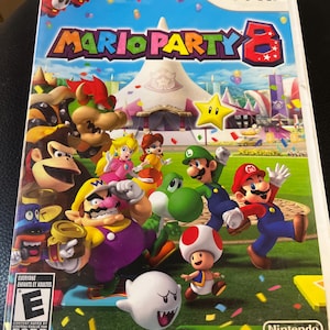 May include: A Wii video game case for Mario Party 8. The cover features a vibrant illustration of various characters, including Mario, Luigi, Peach, and Yoshi, set against a colorful background with the game's title prominently displayed.