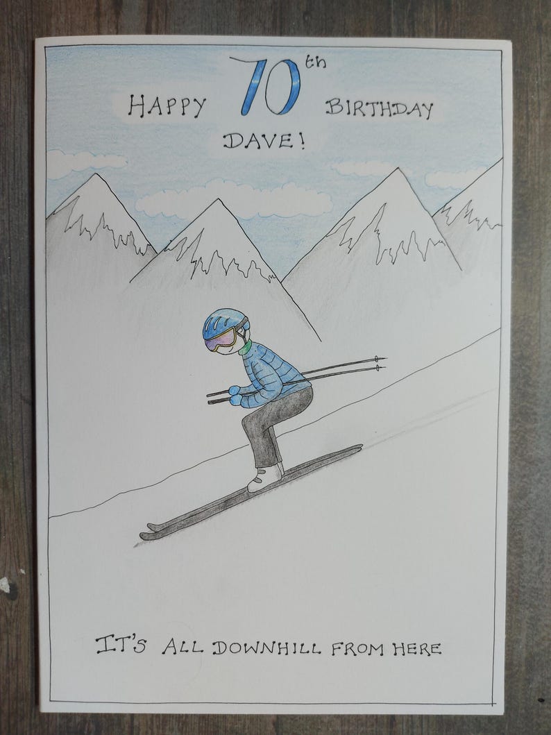 May include: Hand-drawn birthday card with a skier on a snowy slope, mountains in the background, and the text "Happy 70th Birthday Dave!" and "It's All Downhill From Here."