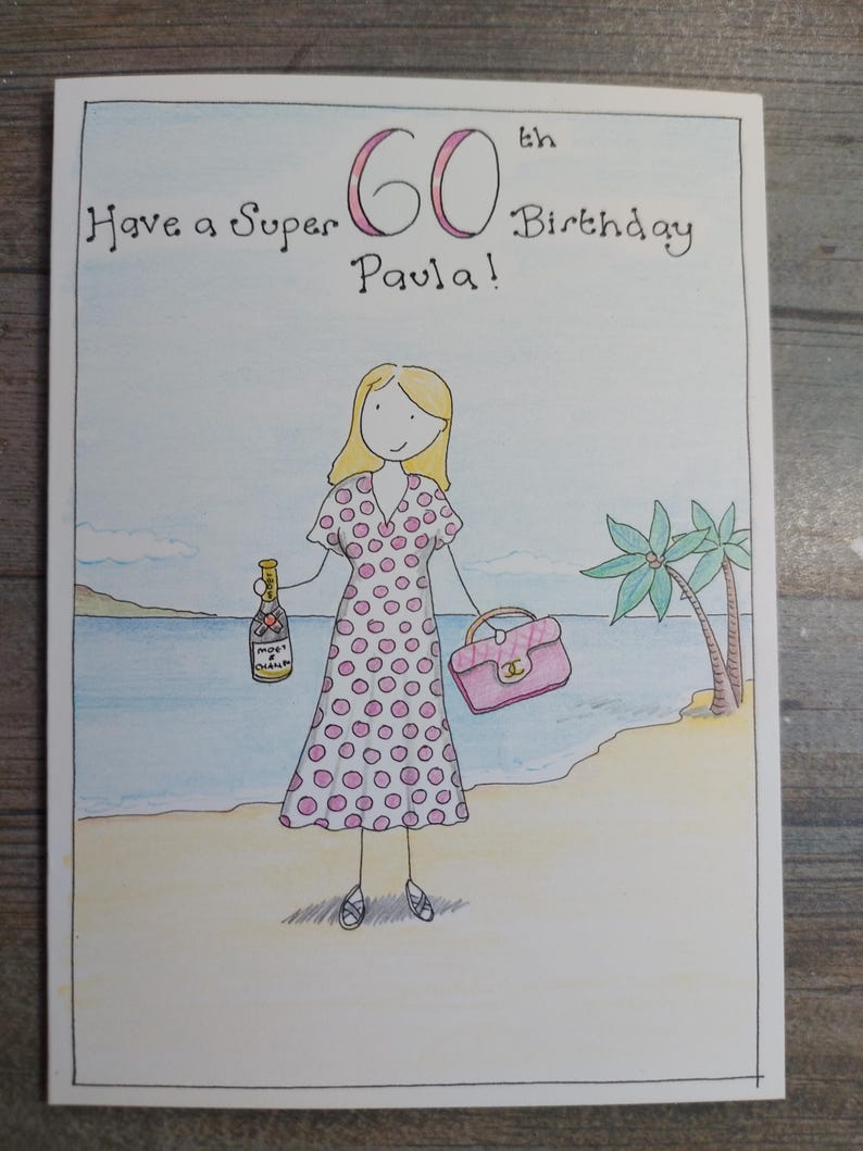 May include: Hand-drawn birthday card with the text "Have a Super 60th Birthday Paula!" A woman in a pink polka dot dress stands on a beach holding a purse and a champagne bottle. Palm trees and ocean in the background.