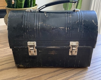 Fiambrera vintage de metal negro con forma de cúpula de Aladdin Industries, de la década de 1950, con asa superior.