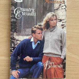 May include: A vintage book cover titled "Country Casuals" with a man and woman in knitwear. The cover includes the text "Patons Moorland" and "Allure Désinvolte". The background features a wooden door and stone wall.