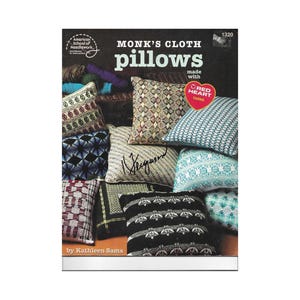 Può includere: Una copertina di libro con vari cuscini in tessuto Monk's Cloth in diversi motivi e colori. Il testo "MONK'S CLOTH pillows" è ben visibile, con "made with RED HEART YARNS" sotto. La copertina include anche il testo "American School of Needlework" e "by Kathleen Sams".
