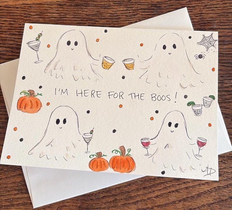Puede incluir: Una tarjeta de felicitaci&oacute;n rectangular con fondo blanco que presenta cuatro fantasmas dibujados a mano sosteniendo varias bebidas alcoh&oacute;licas. El texto "I'M HERE FOR THE BOOS!" est&aacute; centrado. Se ilustran calabazas naranjas, puntos negros y naranjas, una ara&ntilde;a y una telara&ntilde;a.
