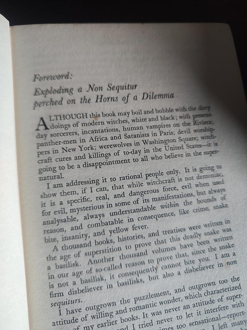 Może przedstawiać: Otwarta strona książki z tekstem zatytułowanym "Foreword: Exploding a Non Sequitur perched on the Horns of a Dilemma". Tekst jest czarny na kremowej stronie. Książka leży na ciemnej powierzchni.