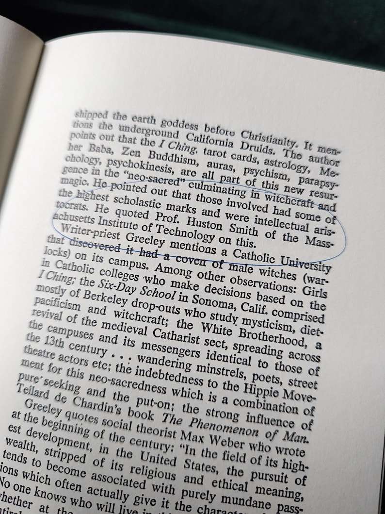 May include: Open book page with printed text. A blue circle highlights the text "Catholic University". The text discusses topics like witchcraft, mysticism, and the I Ching, with references to various authors and institutions.