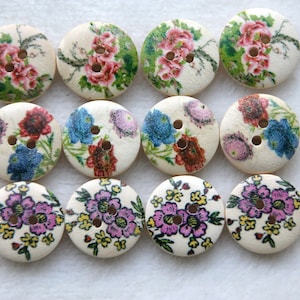 May include: Twelve round wooden buttons with floral patterns. The buttons feature various colors, including pink, blue, green, and white.