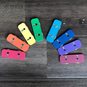 May include: A set of ten colorful wooden toy cars with numbers 1 through 10 printed on them. Each car has a different color and a black dot on the side.