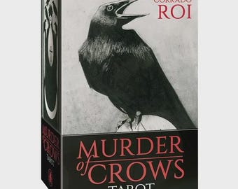 May include: A rectangular tarot deck box featuring a black and white illustration of a crow on the front. The text CORRADO ROI appears in red at the top, while the title MURDER of CROWS TAROT is printed in red and white on a black base.