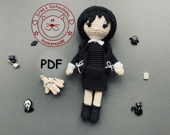 May include: A handmade crochet doll in a black dress with white collar and cuffs, surrounded by small Halloween-themed accessories. The doll has black hair and is labeled "PDF". The image also includes a logo with text "Drea's Saihoubako homemade".