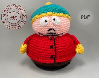 May include: Crocheted plush toy of a cartoon character with a red jacket, pink face, and a green hat. The toy is labeled "PDF" in the background.