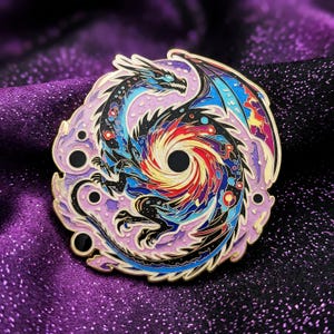 Könnte beinhalten: Runder Emaille-Pin mit einem stilisierten Drachendesign. Der Drache ist in Schwarz-, Blau-, Rot- und Gelbtönen dargestellt, mit einem wirbelnden Wirbel in der Mitte. Der Pin hat einen lavendelfarbenen Rand mit schwarzen Akzenten und einer goldenen Umrandung.