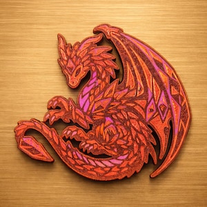Pode incluir: Uma estatueta de dragão de madeira em tons de vermelho, laranja e roxo. O dragão é intrincadamente detalhado com padrões geométricos em suas asas e corpo. A estatueta é colocada em uma posição enrolada, com a cauda e a cabeça próximas.