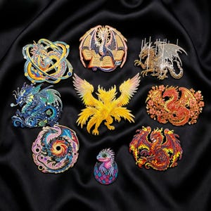 May include: A collection of nine dragon-themed enamel pins in various colors and designs. The pins feature dragons with wings, curled bodies, and intricate details. The pins are set against a black satin background.