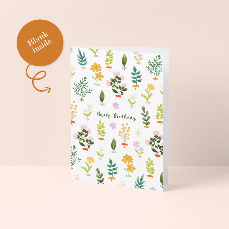 K&ouml;nnte beinhalten: Eine wei&szlig;e Geburtstagskarte mit einem floralen Muster aus verschiedenen gr&uuml;nen Bl&auml;ttern und bunten Blumen. Die Worte "Happy Birthday" sind in gr&uuml;ner Schrift geschrieben. Die Karte ist innen leer.