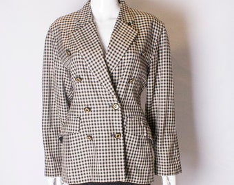 May include: A black and white gingham blazer with a double breasted closure and gold buttons. The blazer is worn over a black skirt.