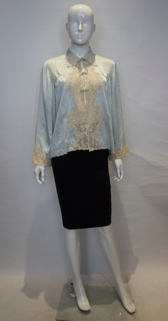 a vintage 1920s pale blue silk and lace bed jacket