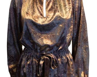 May include: A long-sleeved, gold and purple blouse with a gathered waist and a tie belt.