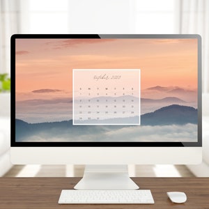 May include: A computer desktop with a calendar wallpaper featuring a misty mountain landscape at sunset. The calendar is for October 2023.